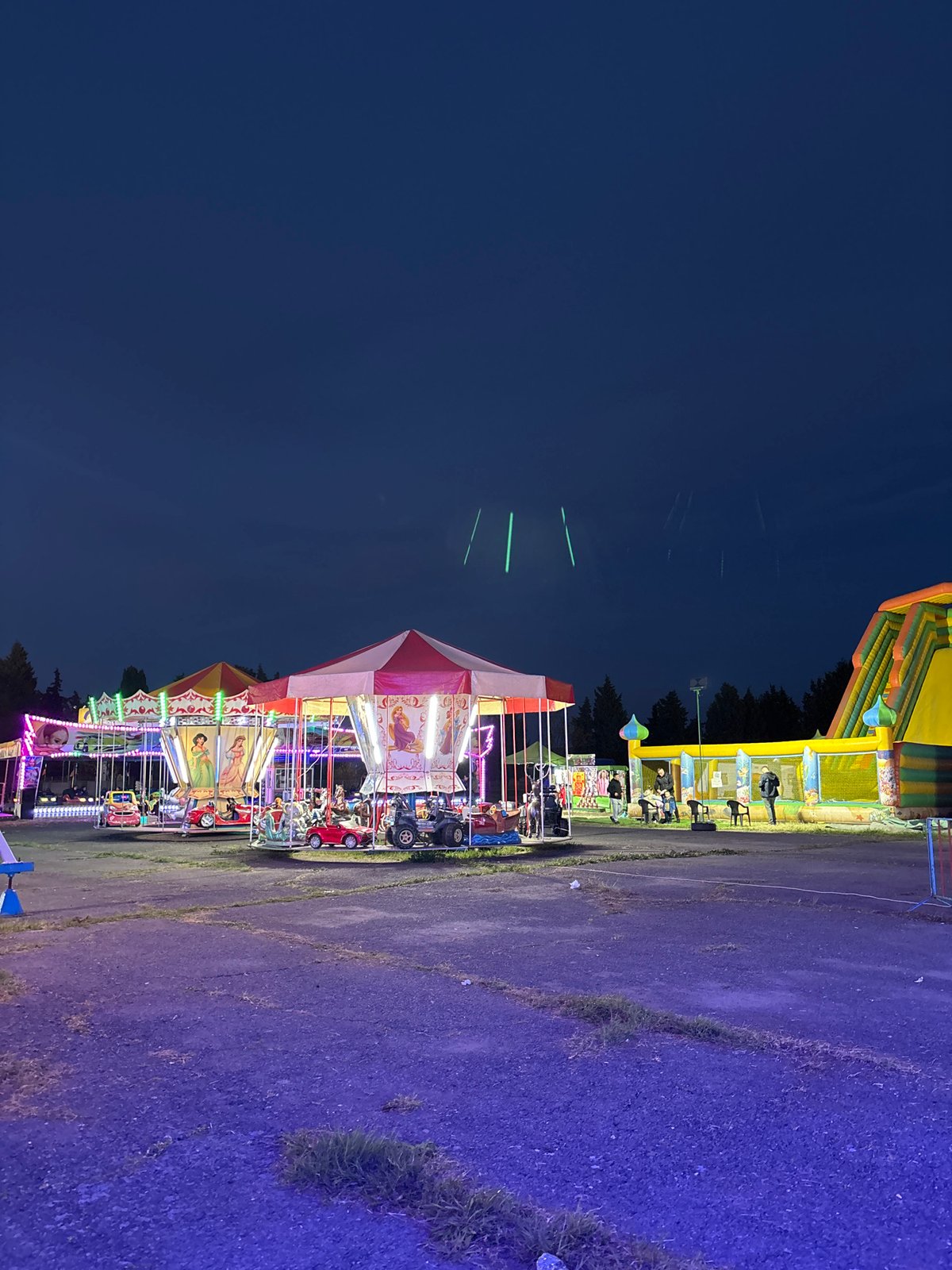 Evening carnival operates in Pomorie, Bulgaria with illuminated rides