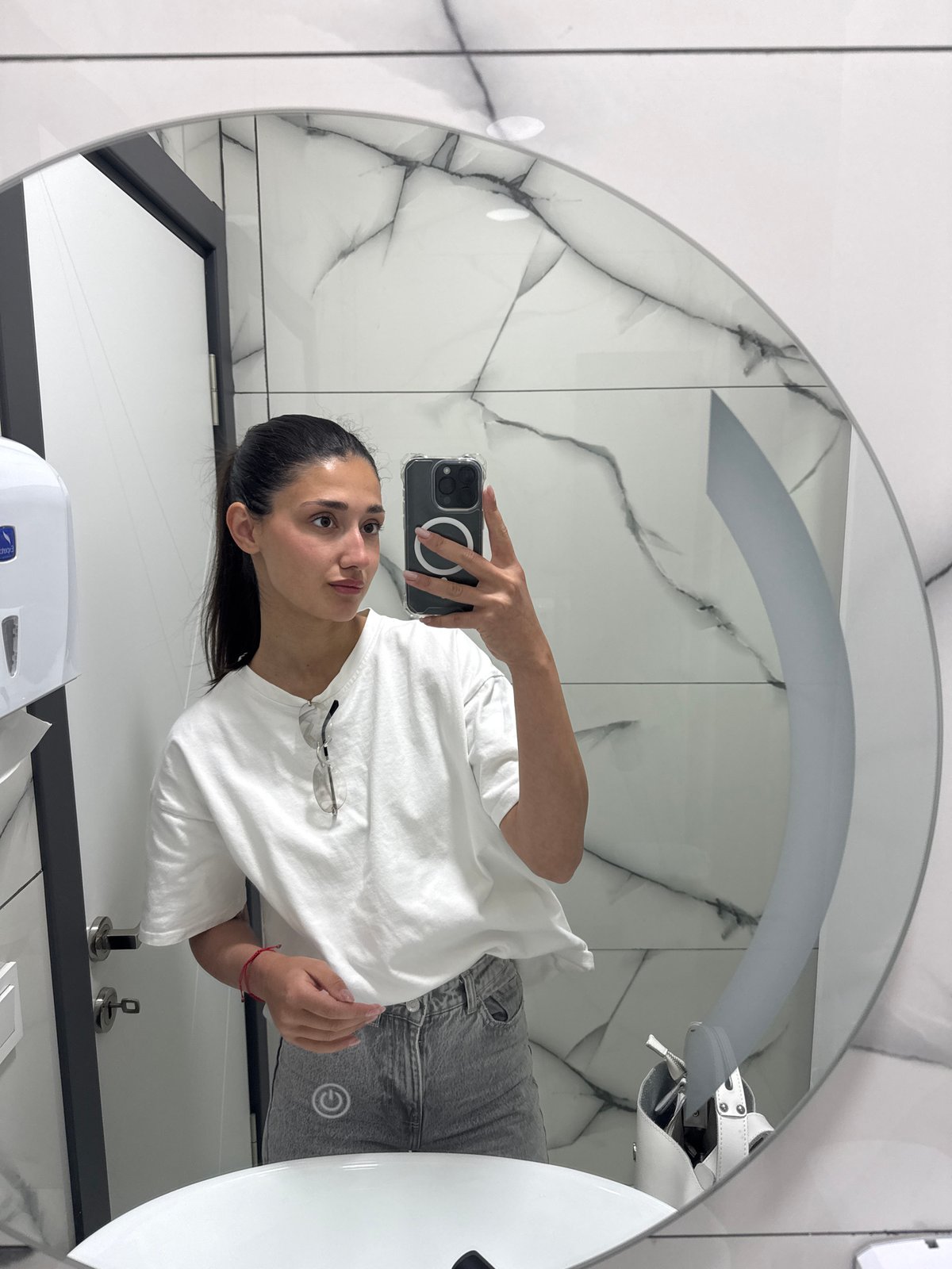 Woman takes bathroom mirror selfie in Podgorica