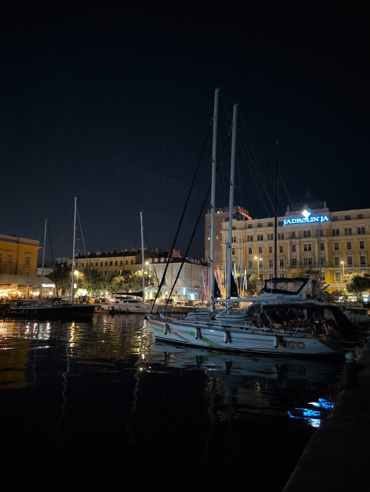 Rijeka harbor at night, sailboats and cargo ships docked