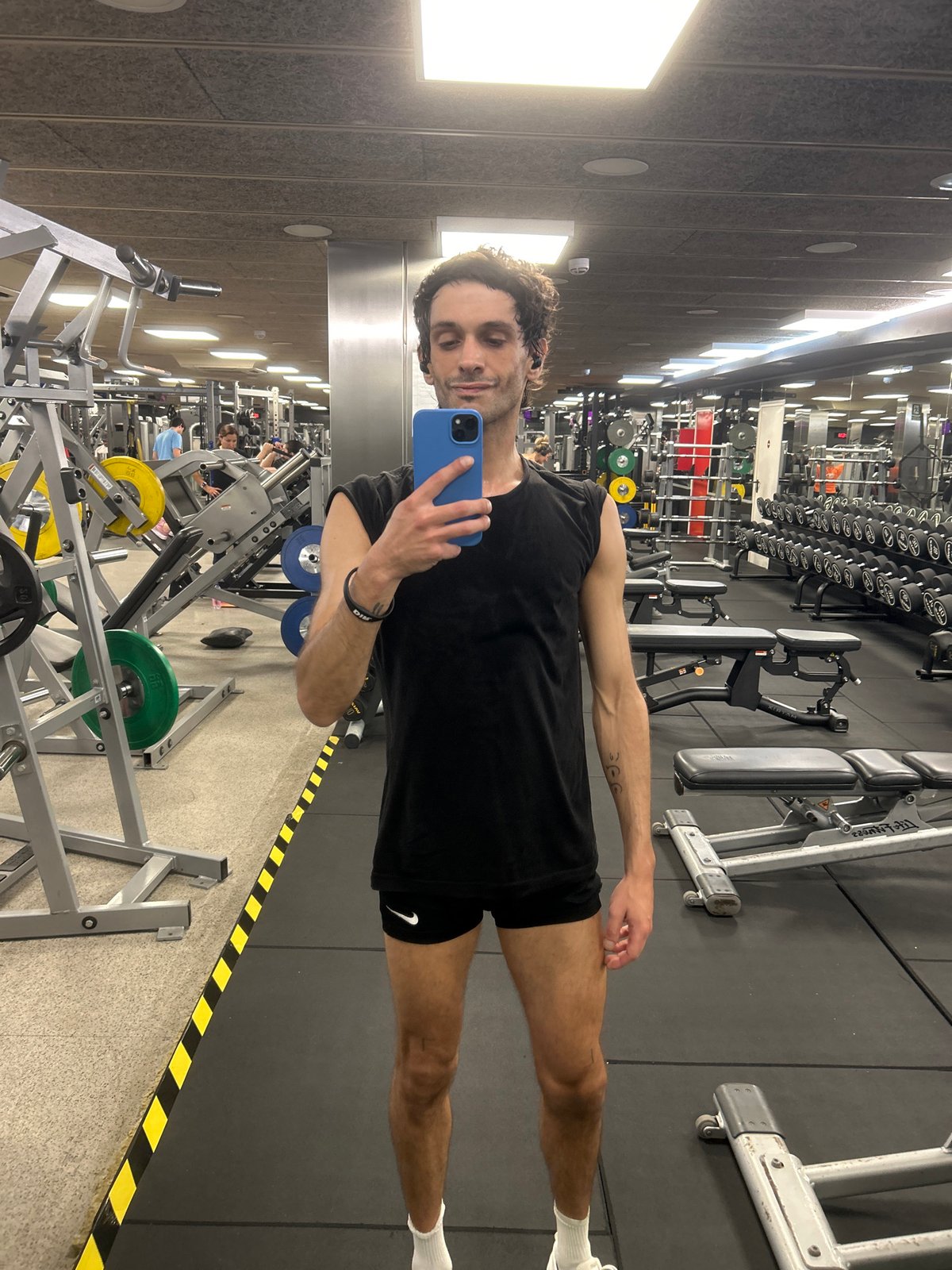 Mirror selfie at a Barcelona gym, weights in the background.