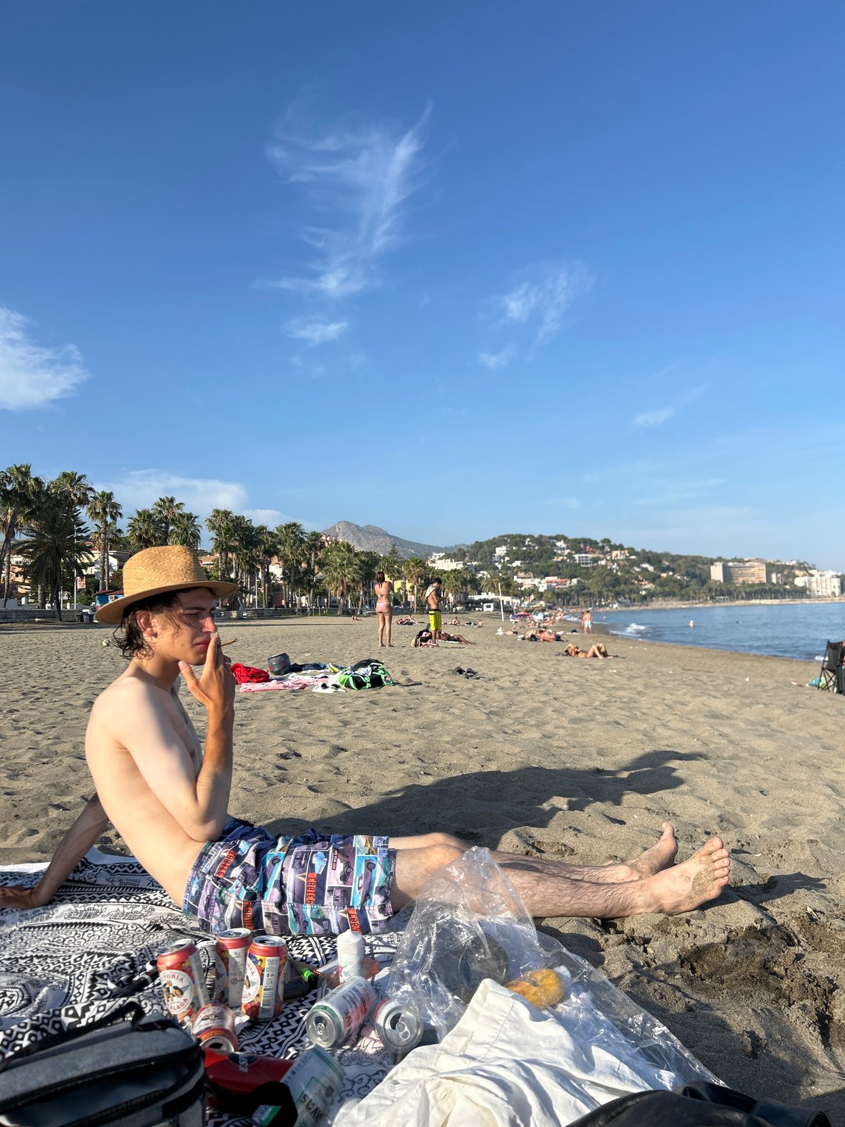 Beachgoers relax, socialize on Málaga coast during summer afternoon