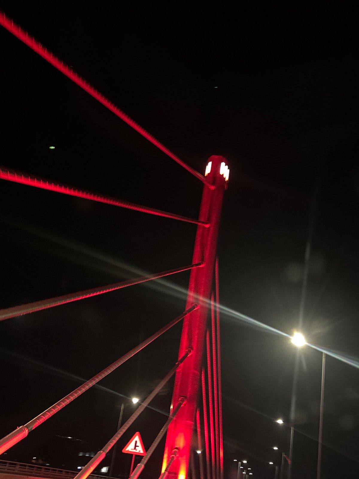 Millennium Bridge glows red in nighttime illumination, Podgorica