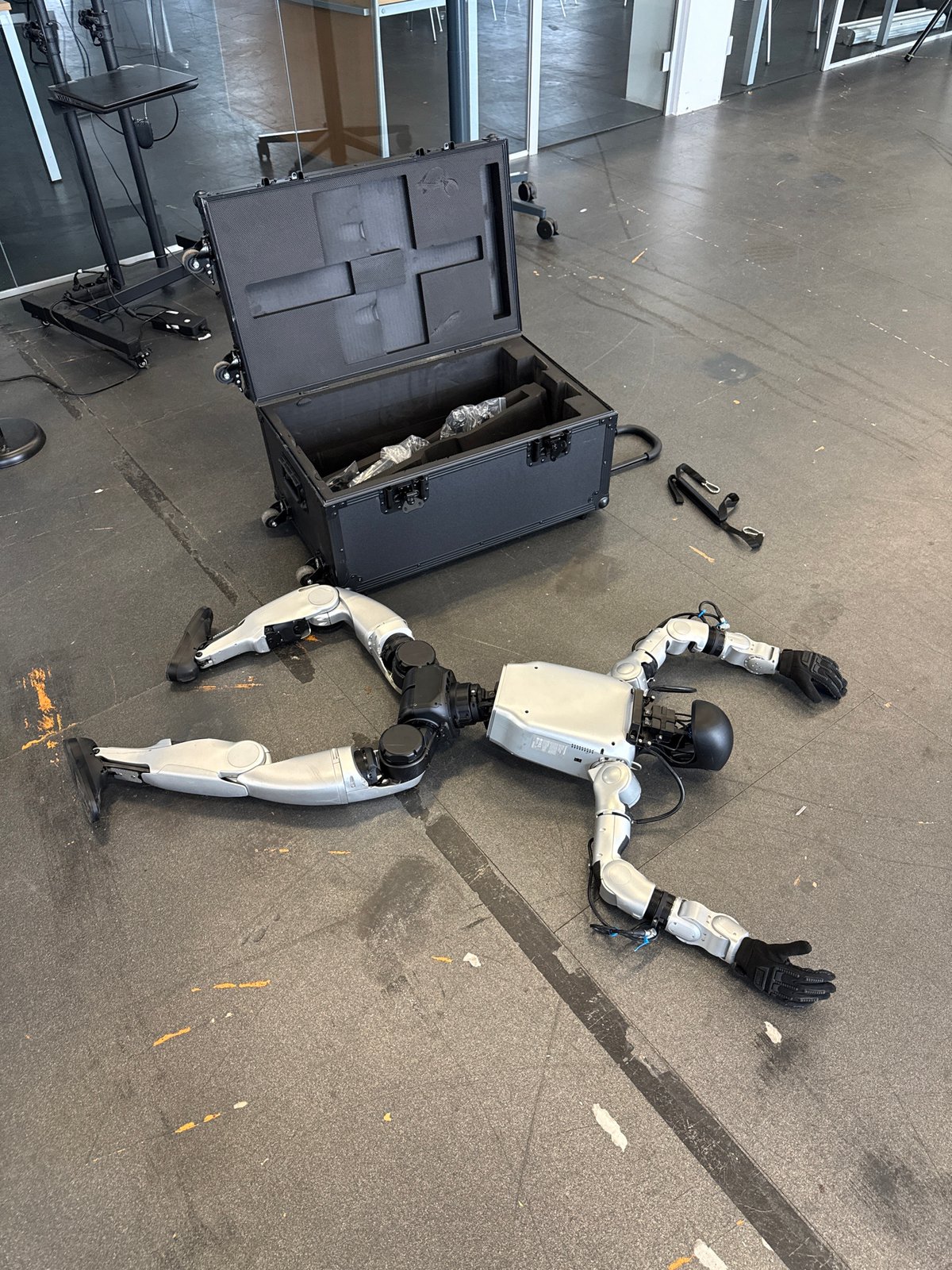 Humanoid robot found motionless on floor, arms splayed