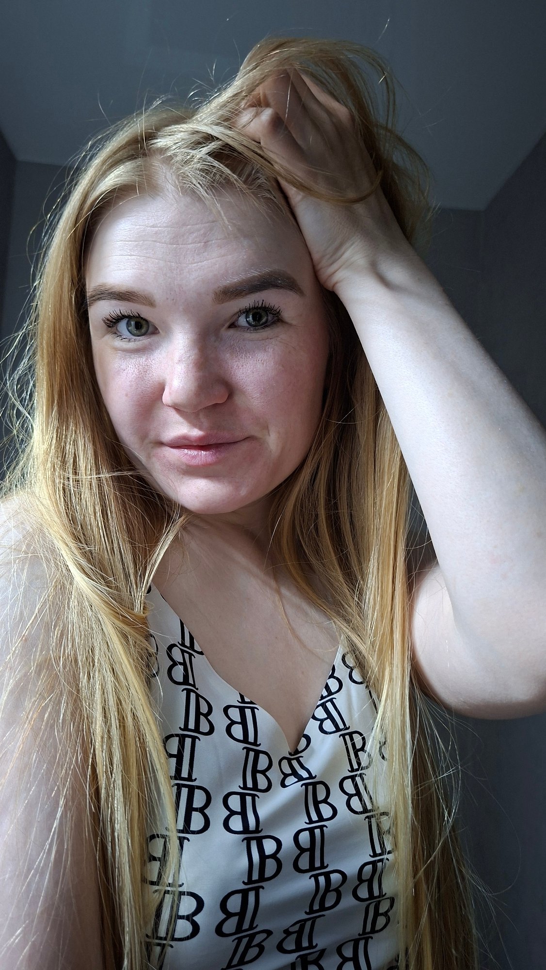 Woman in branded white shirt photographed indoors in Chaikovsky