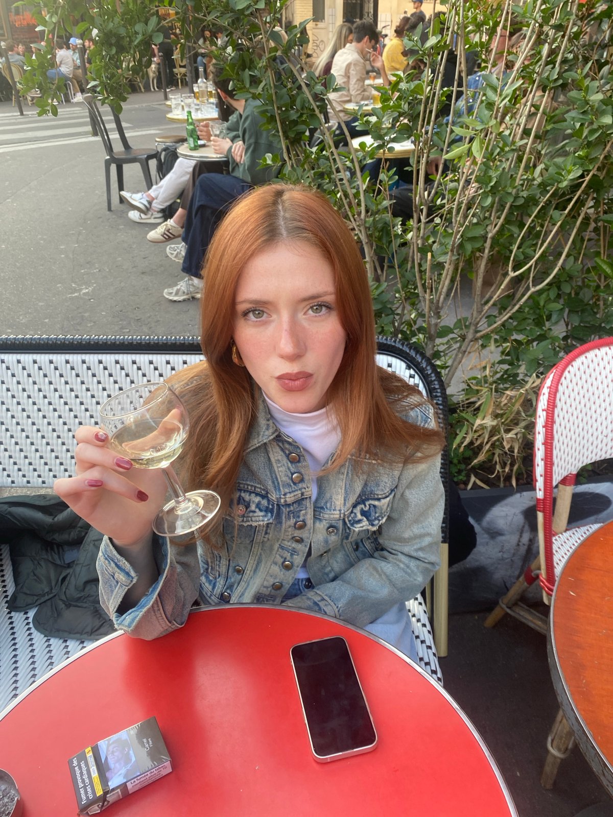 Woman enjoys wine at Paris cafe during evening hours