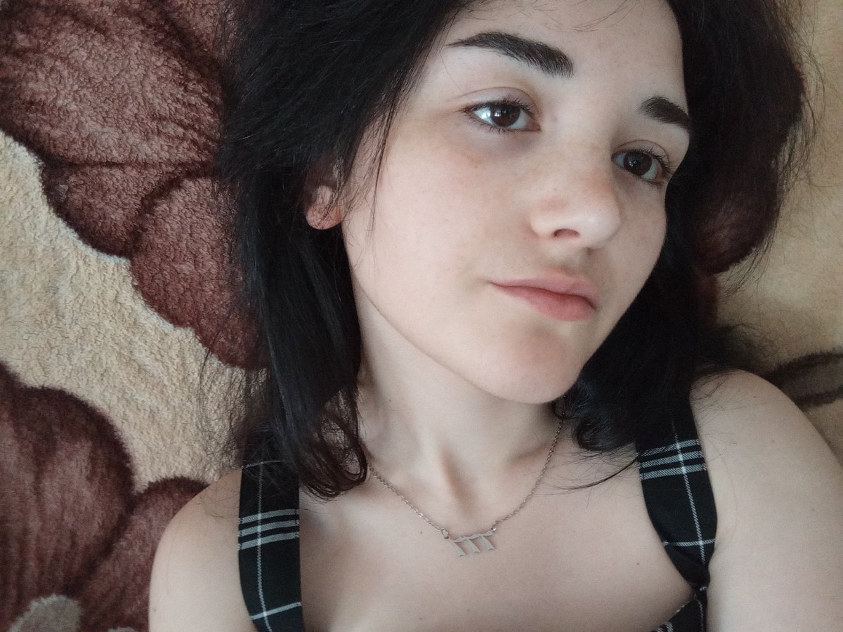 Woman takes morning selfie on patterned blanket