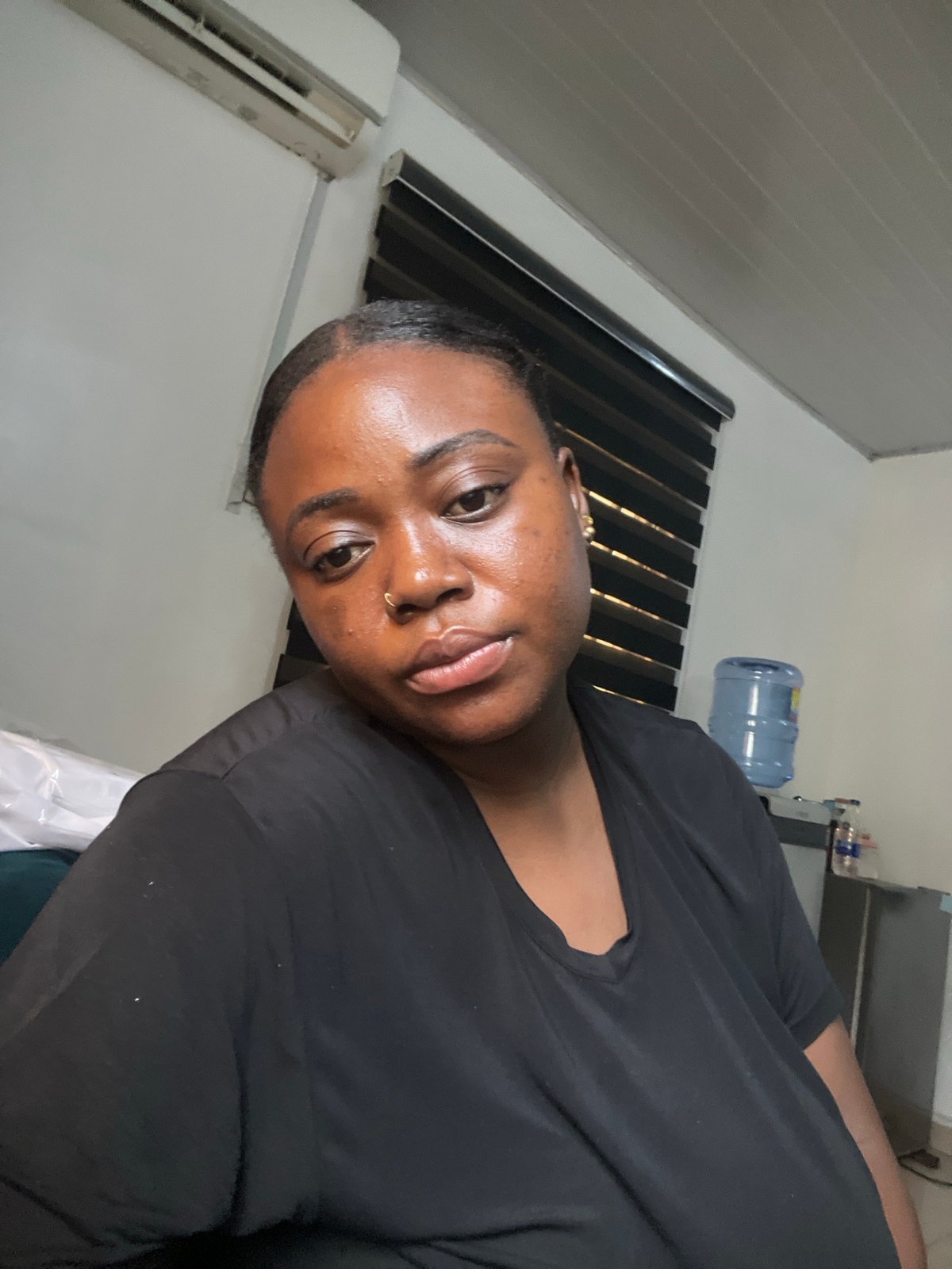 Woman with gold piercings photographed indoors in Abuja