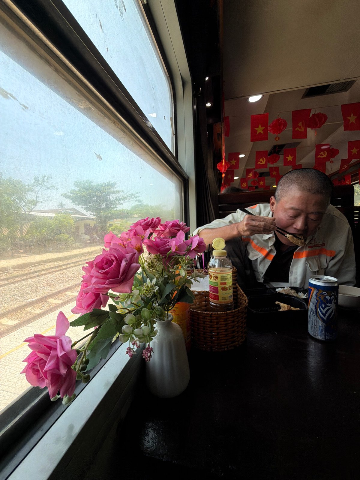 Man eats with chopsticks aboard moving train in Huế