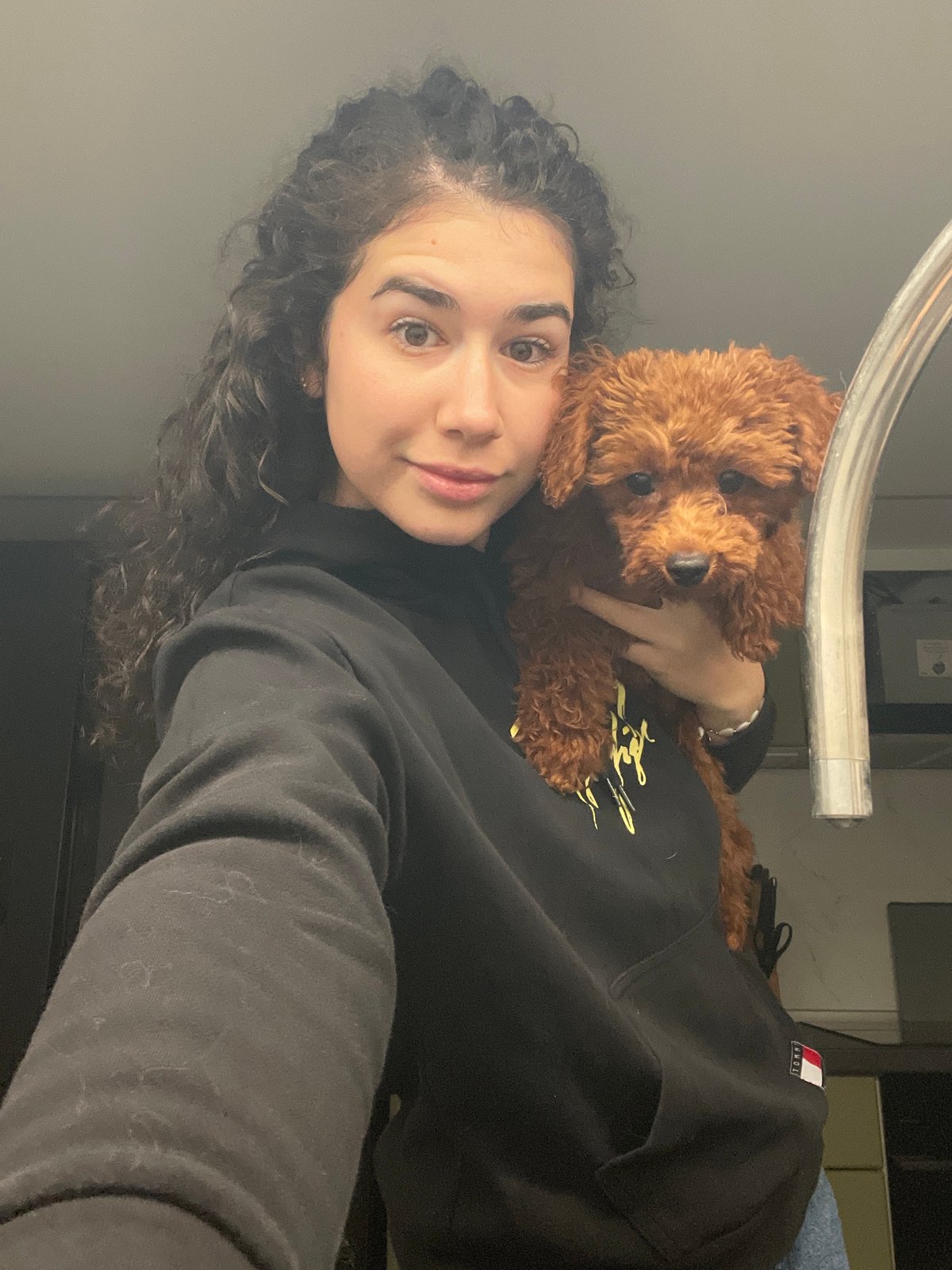 Woman poses with small brown poodle in Sofia apartment