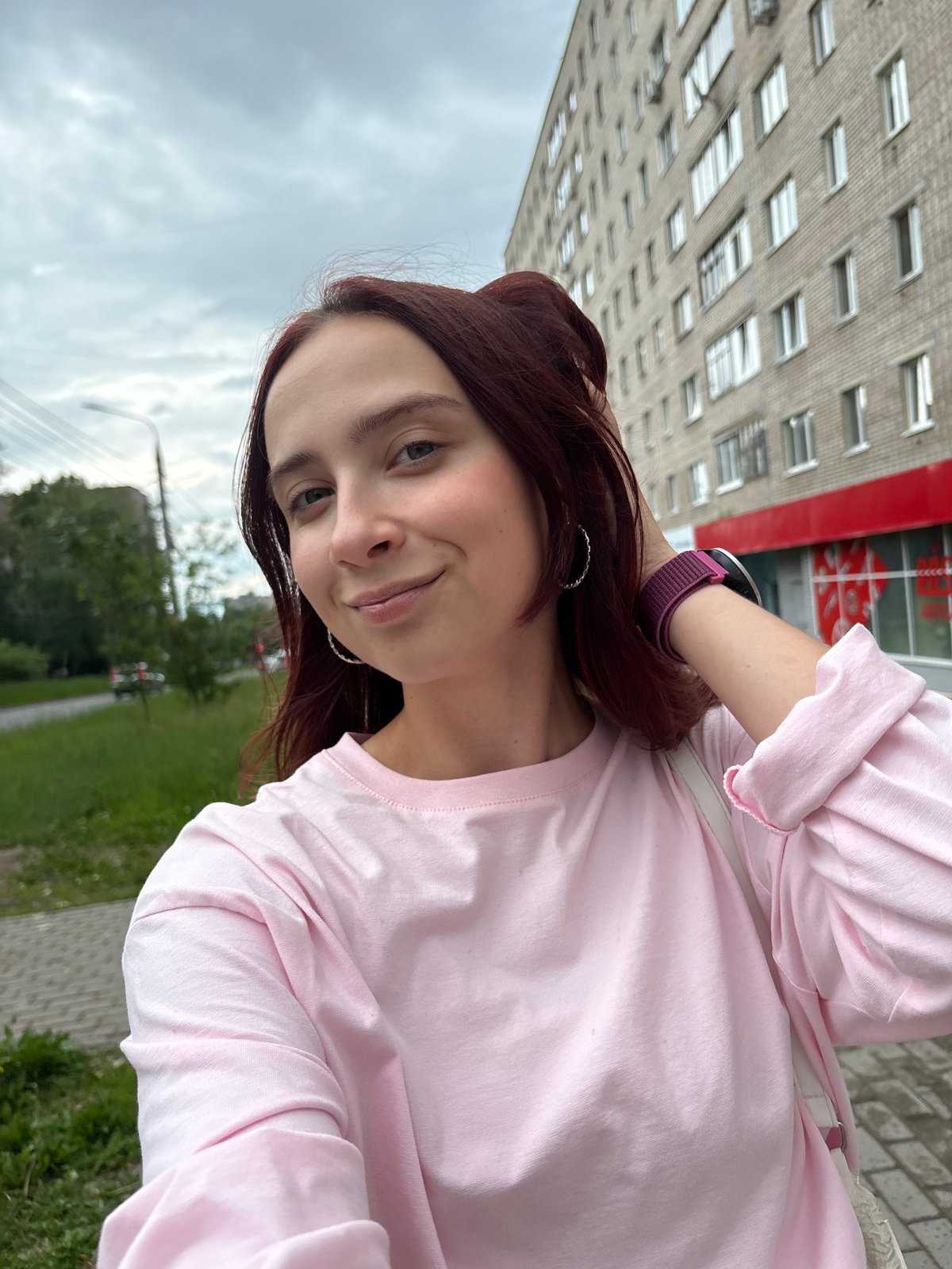 Young women take selfies on cobblestone street in Izhevsk