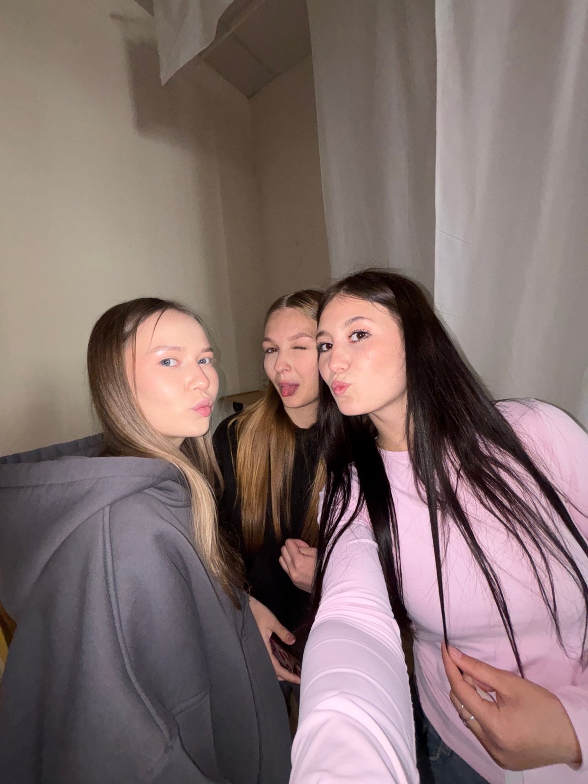 Young women take casual selfies indoors in Chaikovsky, Russia