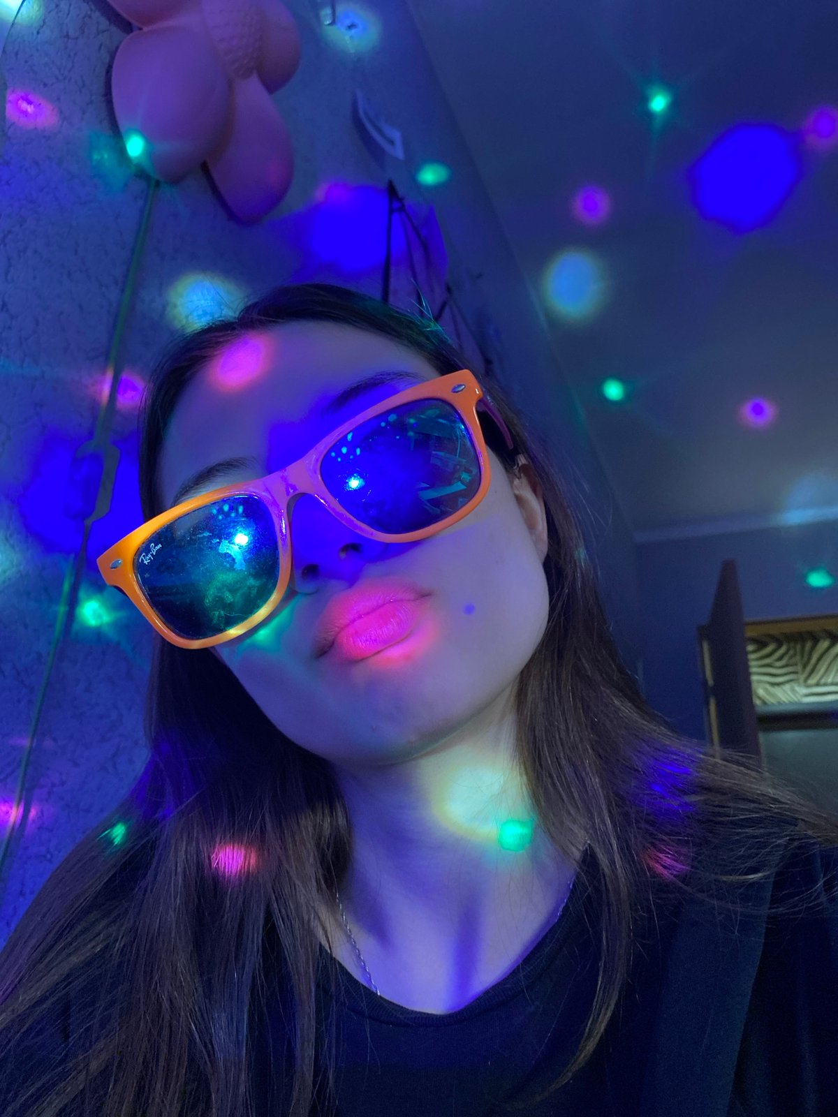 Person poses with multiple glasses under disco lights in Votkinsk