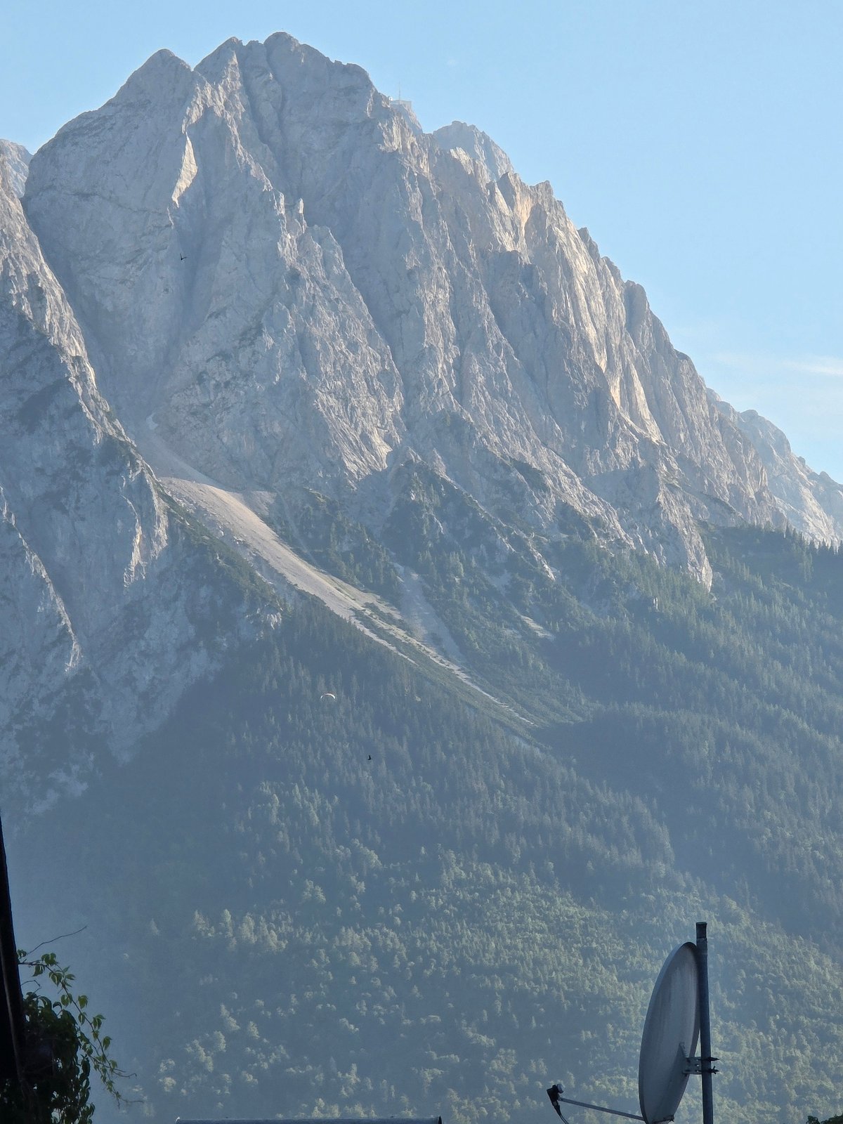 Paragliders drift over Garmisch-Partenkirchen with the Zugspitze behind