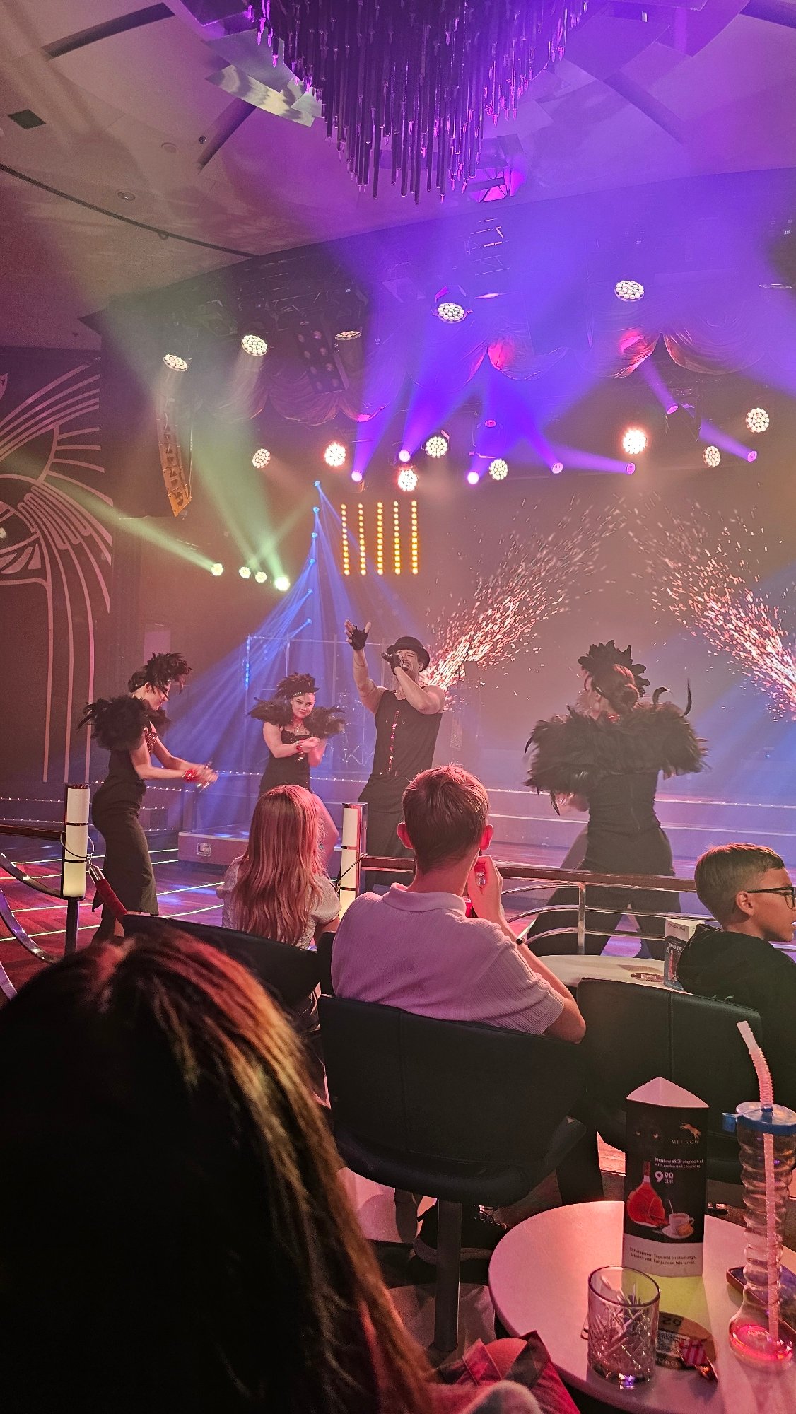 Four performers on a pyrotechnic-lit stage, mid-show.