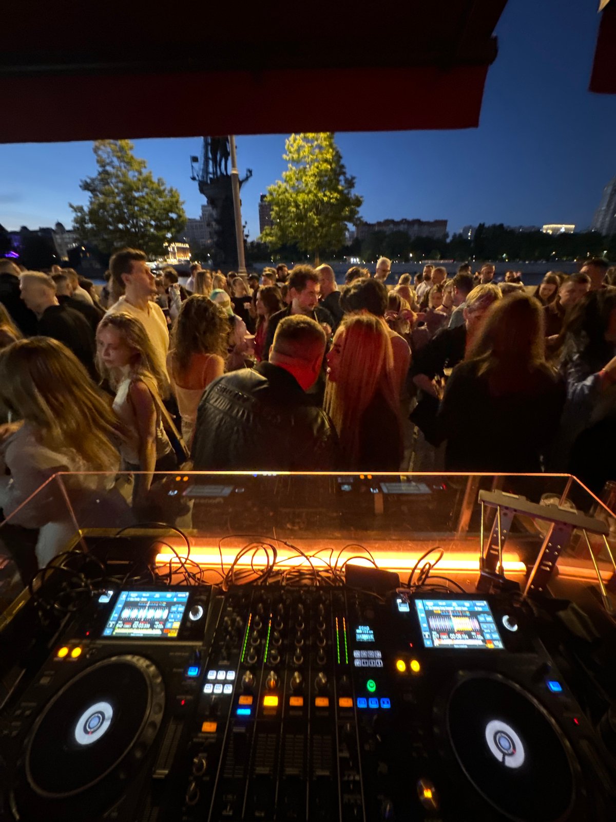 Evening riverbank party features female DJ in Moscow