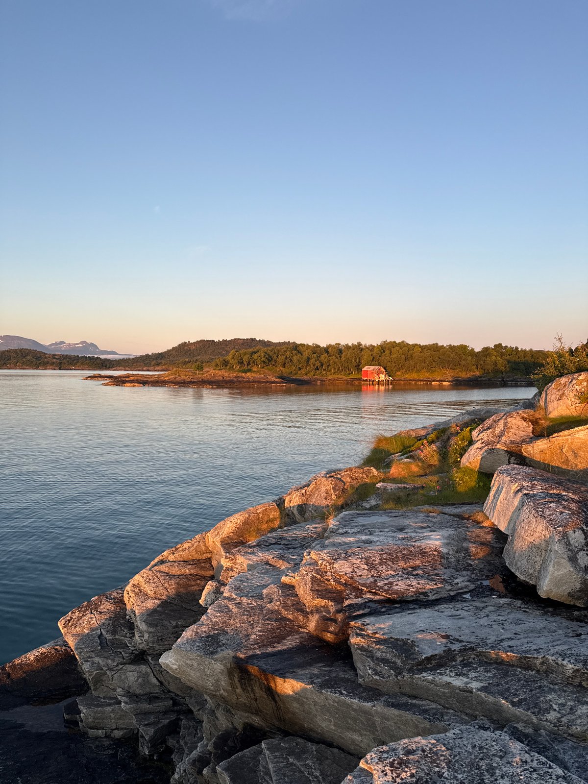 Golden hour along the fjord shoreline in Harstad, Norway