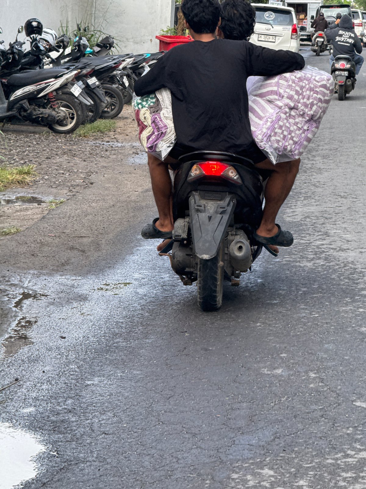 Motorcyclist travels road in Nusa Penida carrying package