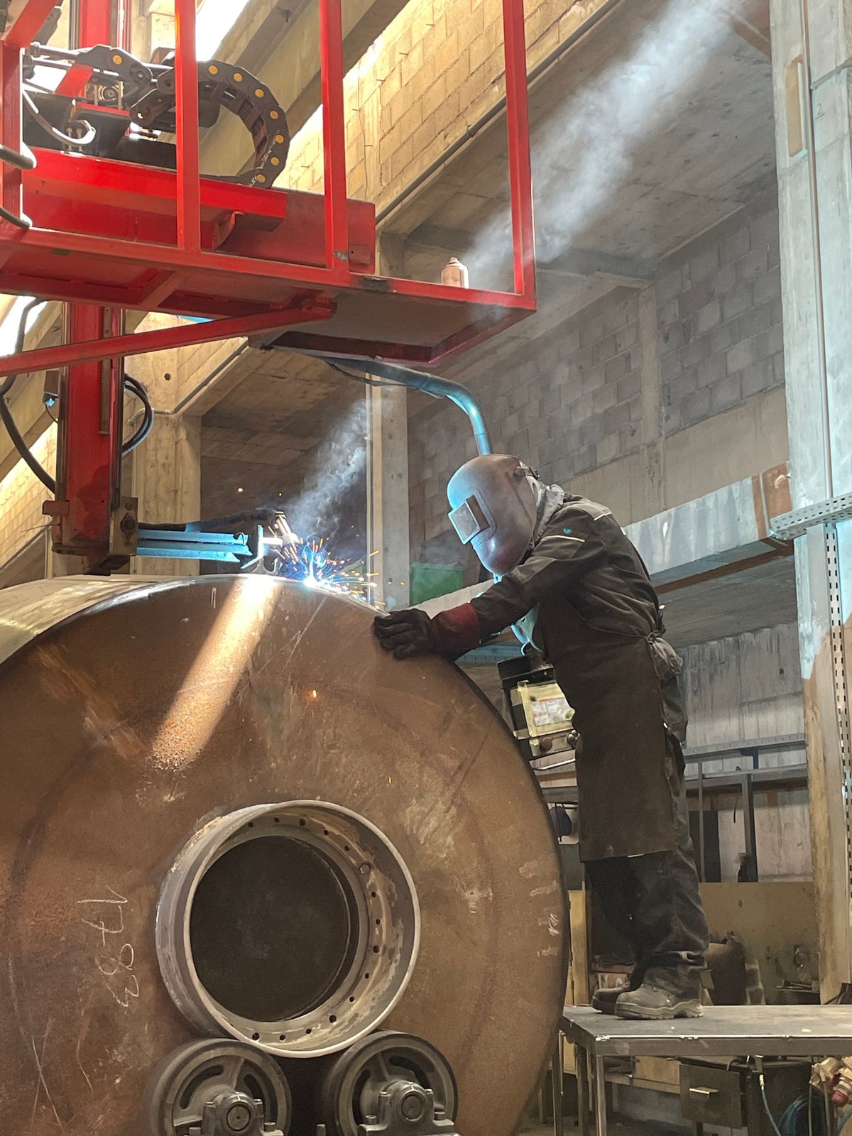 Welder works on metal cylinder in Montenegro industrial facility