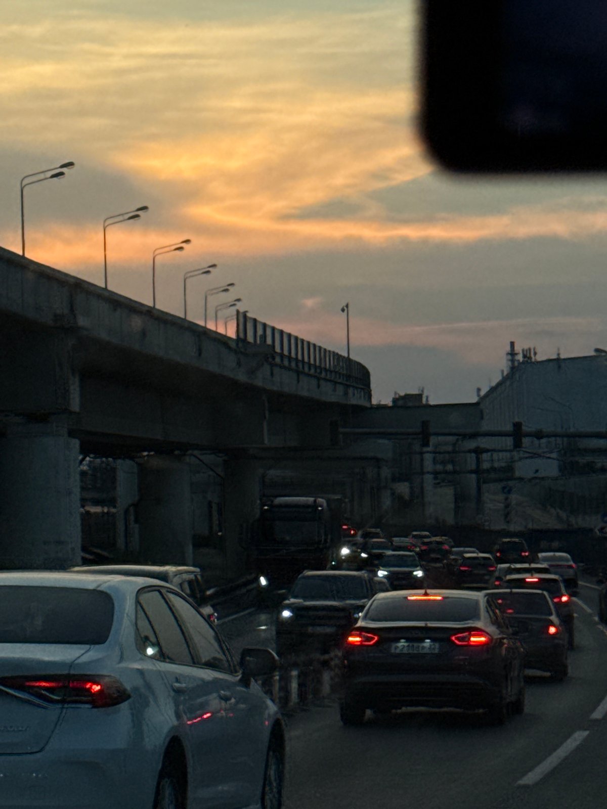 Woman with pink suitcase takes selfies in Moscow at dusk