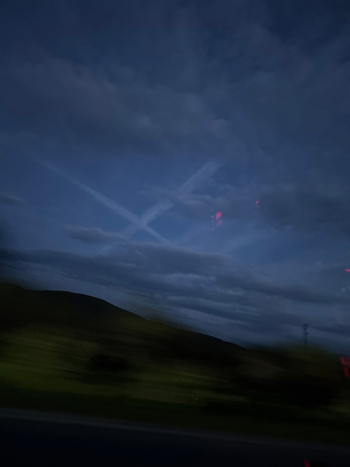 Airplane contrails spotted in twilight sky over Bulgarian village
