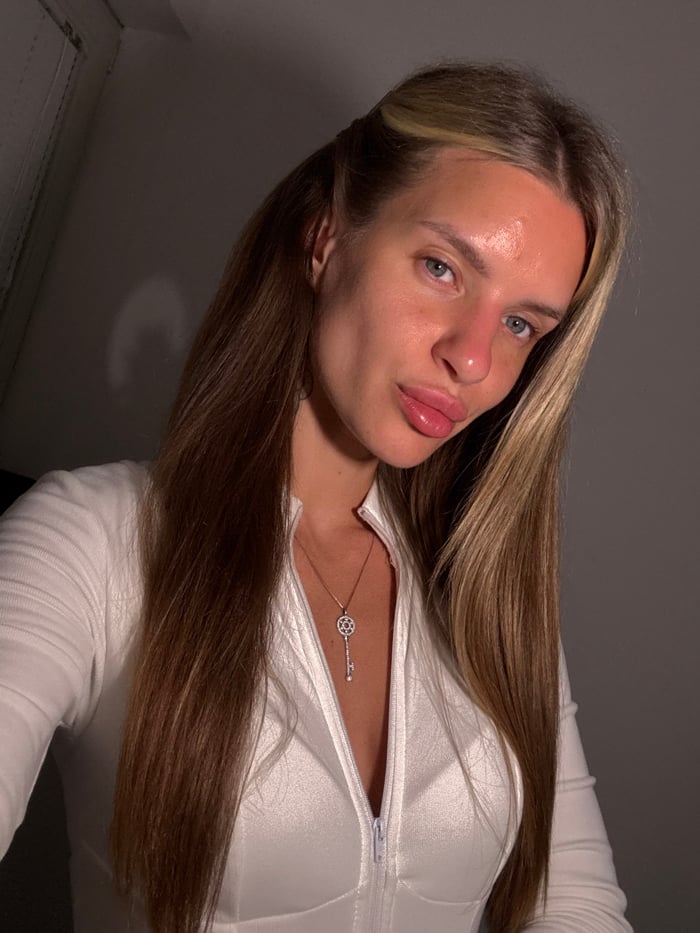 Woman takes selfies in Berlin bathroom wearing white jumpsuit