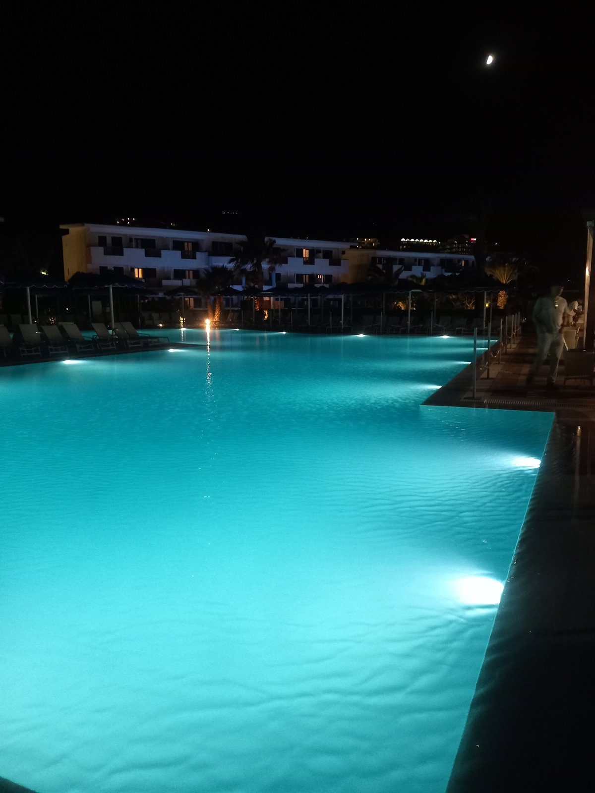 Resort evening in Kos: pool lights, palm trees, live music