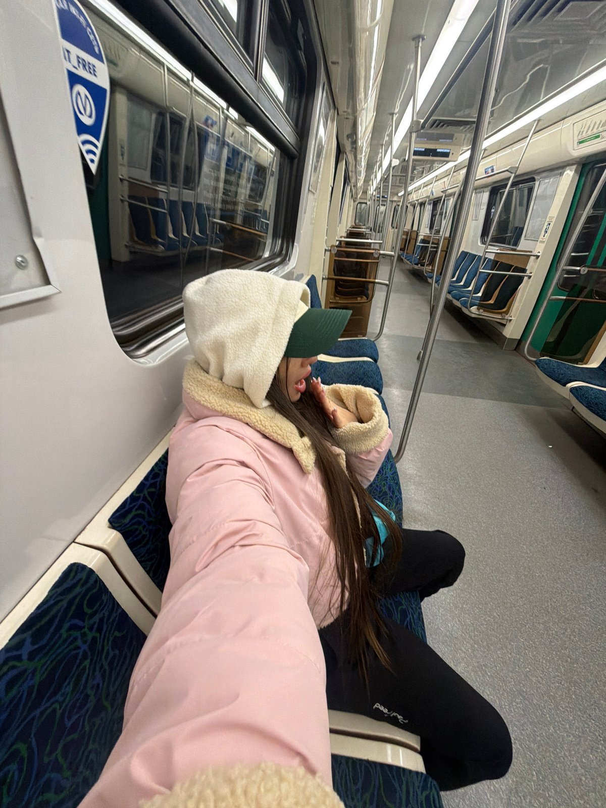 Woman sleeps across metro seats in Saint Petersburg train