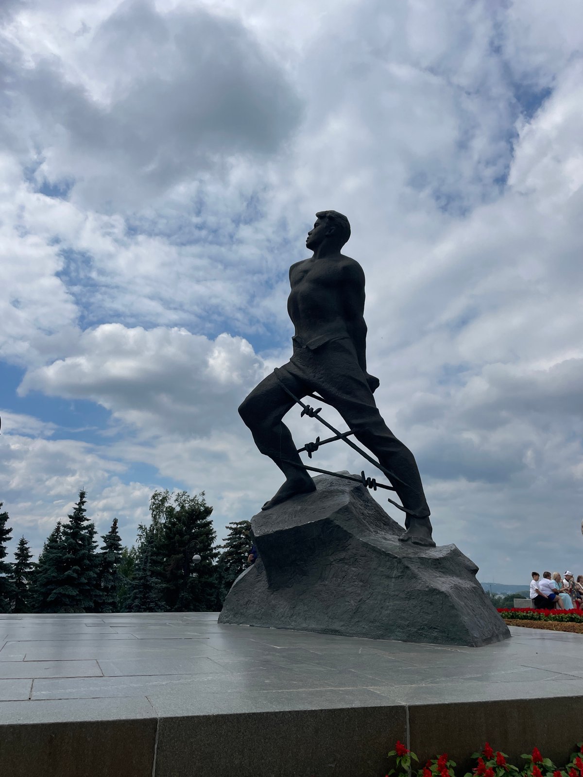 Bronze statue shows struggling figure on jagged rock