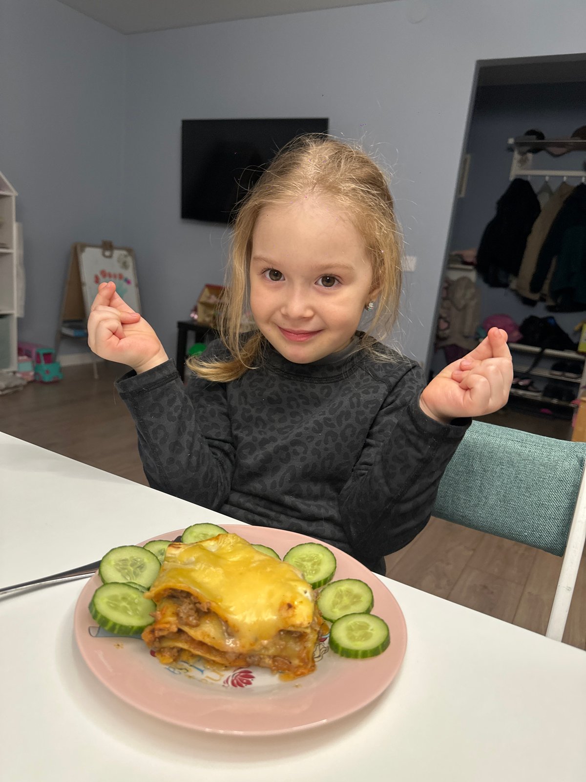 Girl eats meal near pink artwork in Chaikovsky home