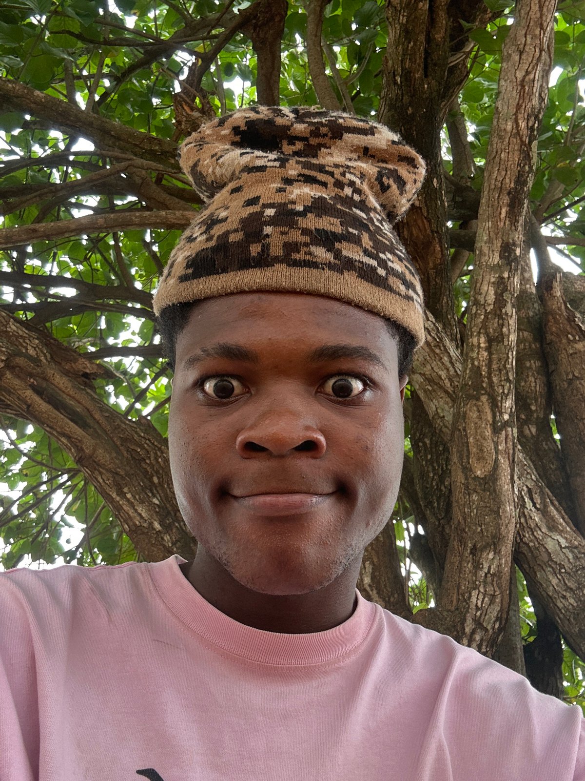 Young man takes playful selfies outdoors in Nigeria