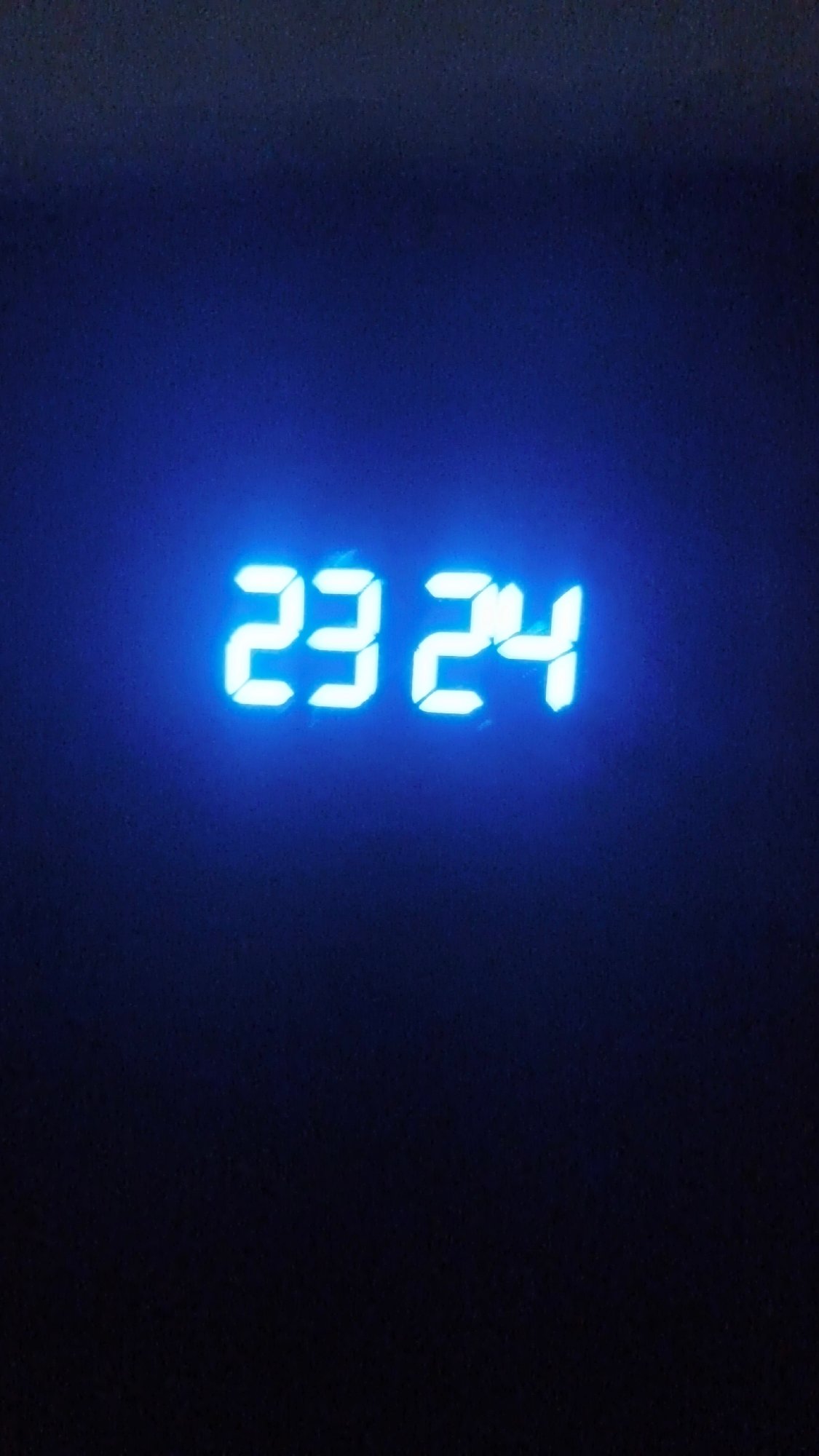 Digital clock shows 23:24 in bright blue numbers