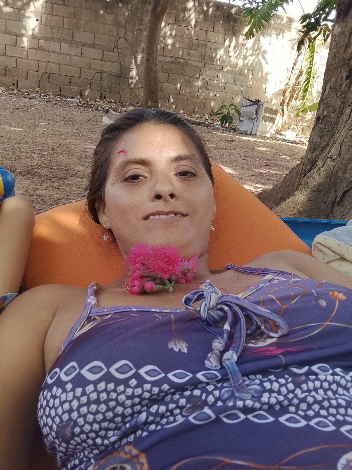 Family relaxes outdoors with flowers in Venezuelan neighborhood