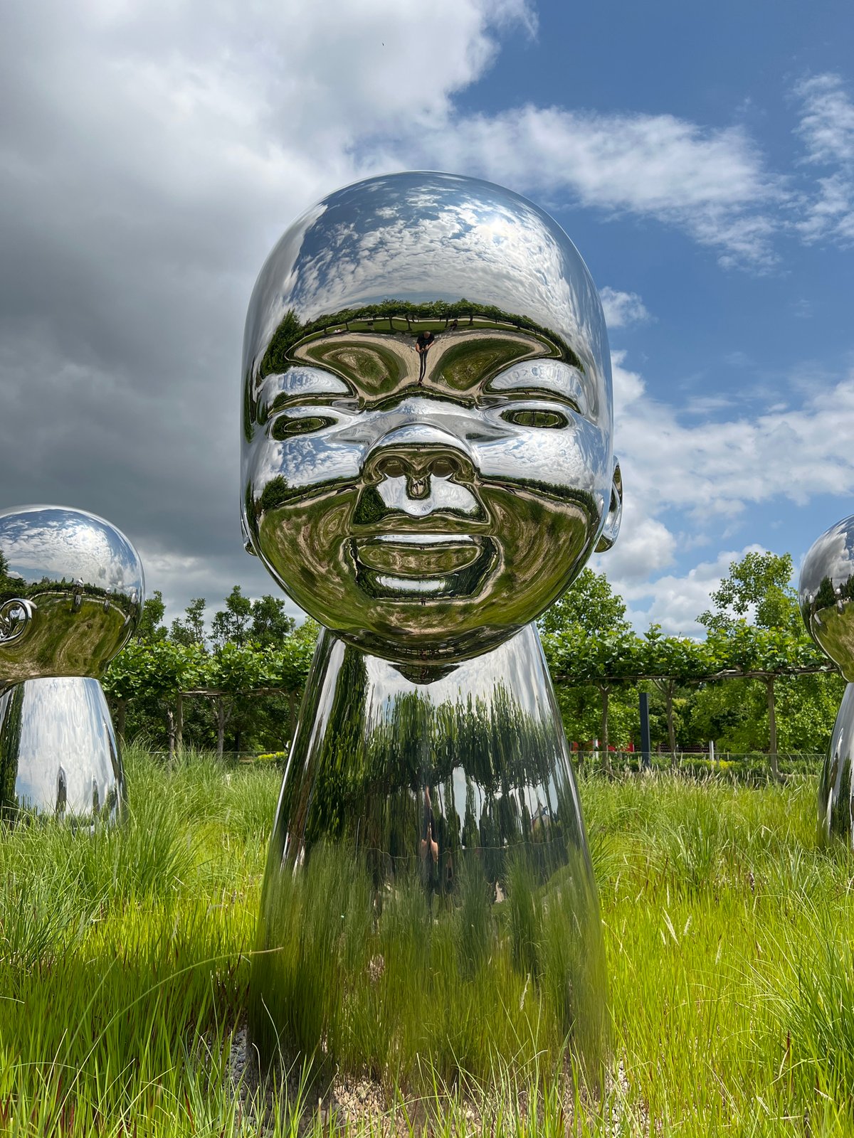 Morning scenes around reflective baby head sculptures in Krasnodar