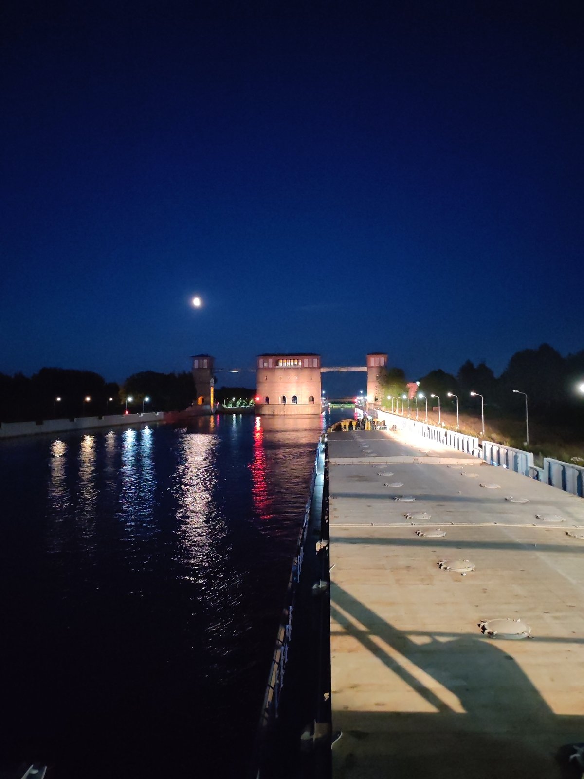 Barge passes through illuminated Rybinsk Lock at night