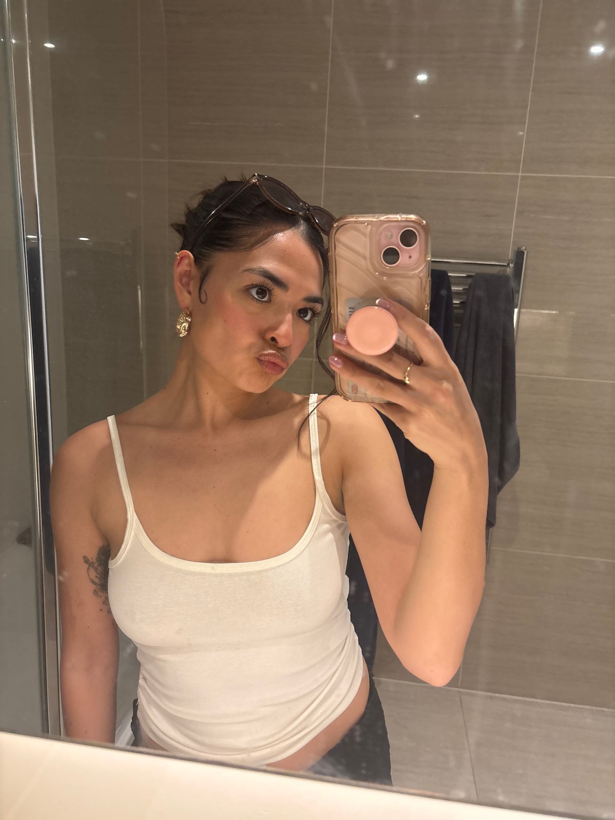 Woman takes bathroom selfie with pink iPhone in London
