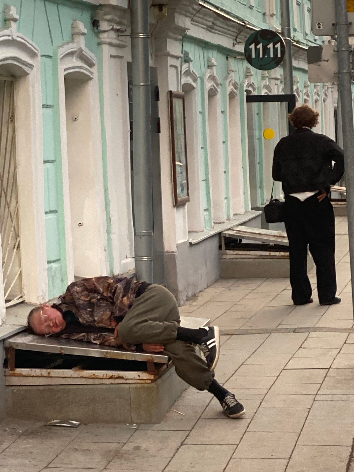 Man enters utility access point on Moscow sidewalk