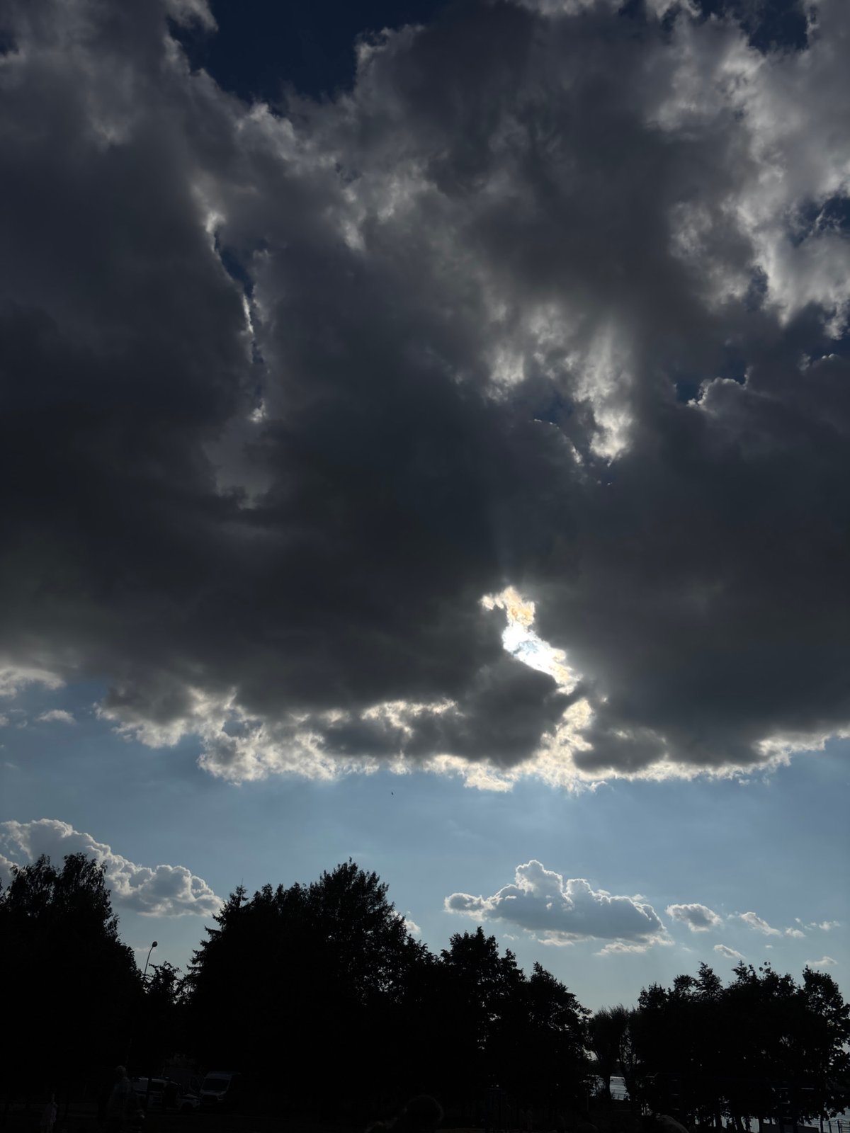 Storm clouds and sunlight compete across a dramatic sky.