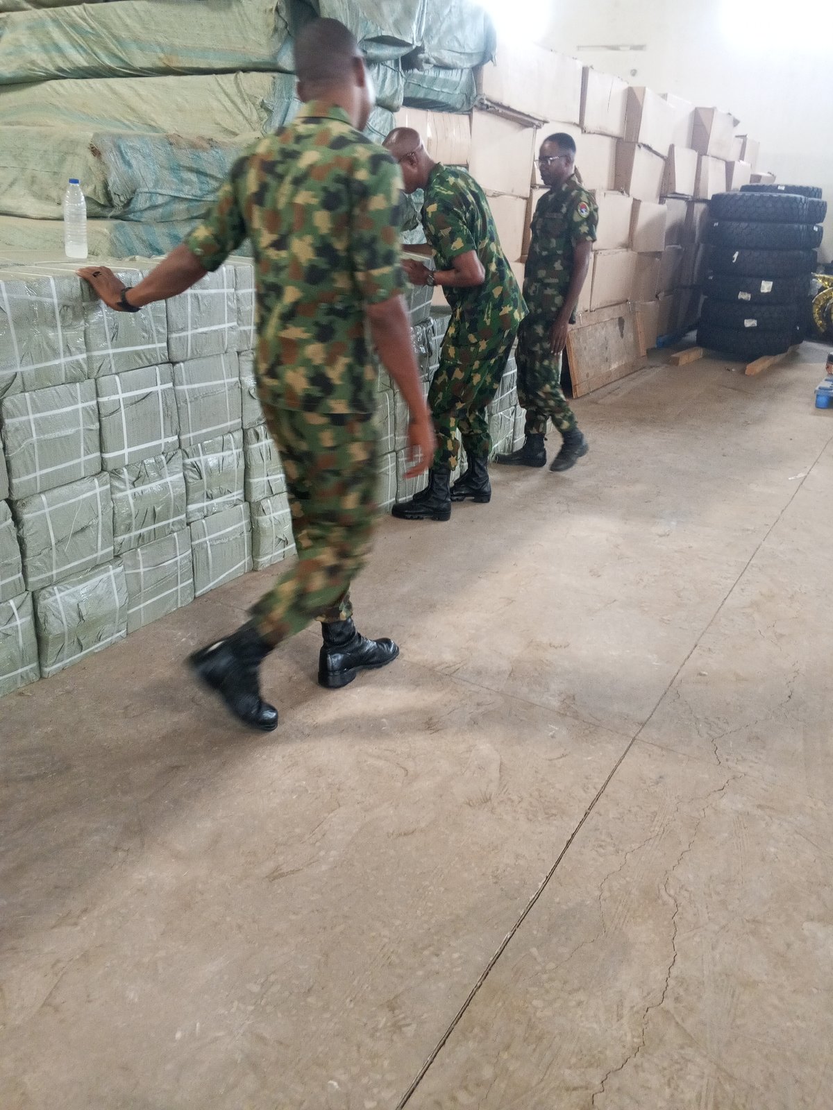 Military personnel observed handling packaged goods in warehouse facility