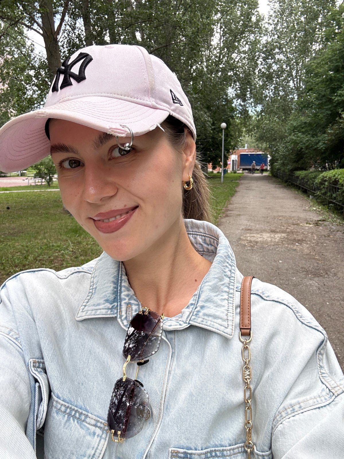 Woman takes selfies near jasmine flowers while man sleeps nearby