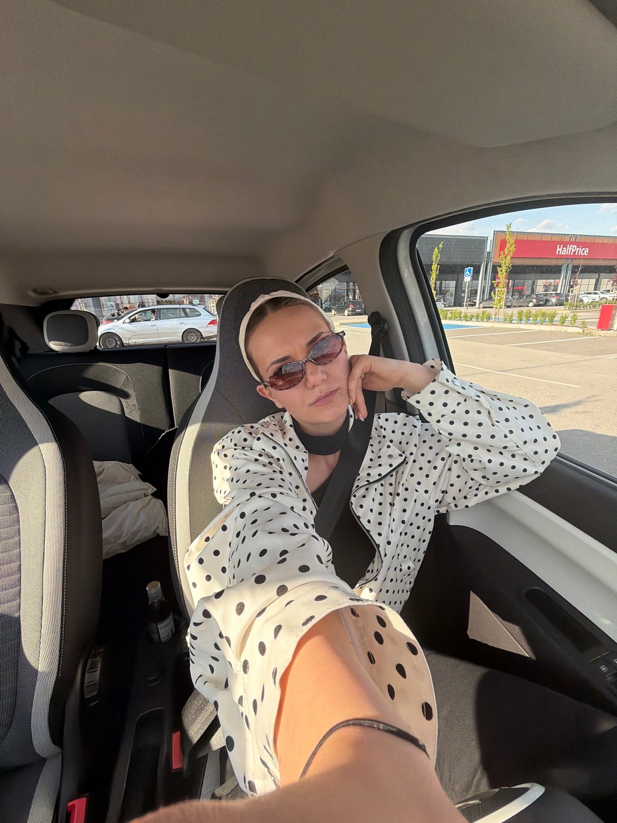 Woman in polka-dot jacket observed in car passenger seat, Sofia