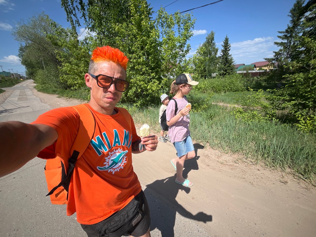 Man in orange enjoys ice cream during morning walk in Chaikovsky