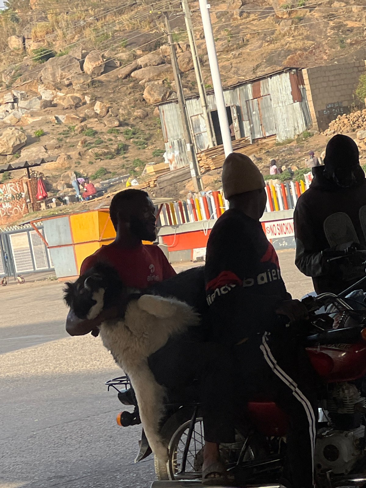 Morning street gathering captured around motorcycle in Jos, Nigeria
