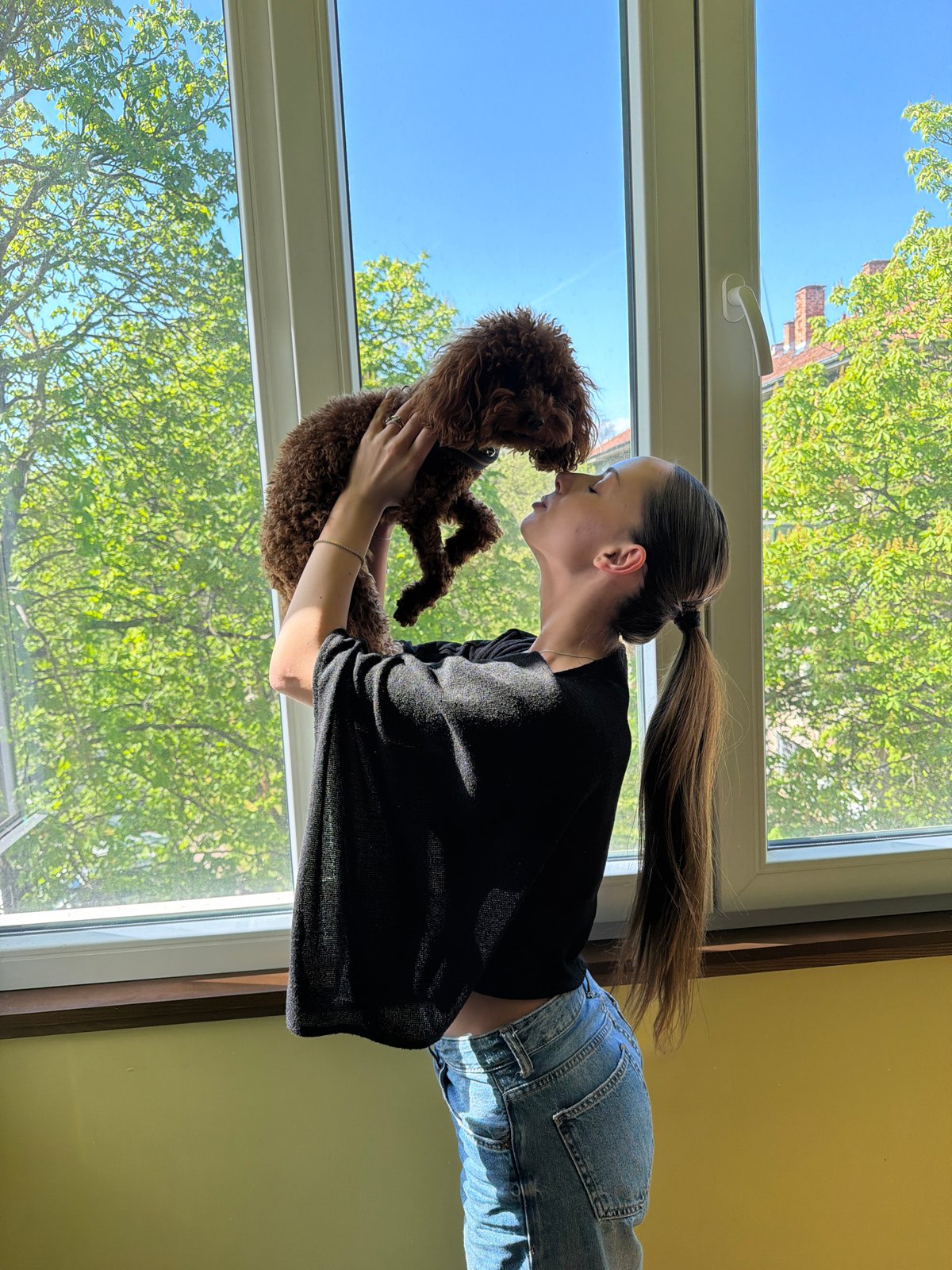 Woman celebrates with poodle and berry cake in Sofia