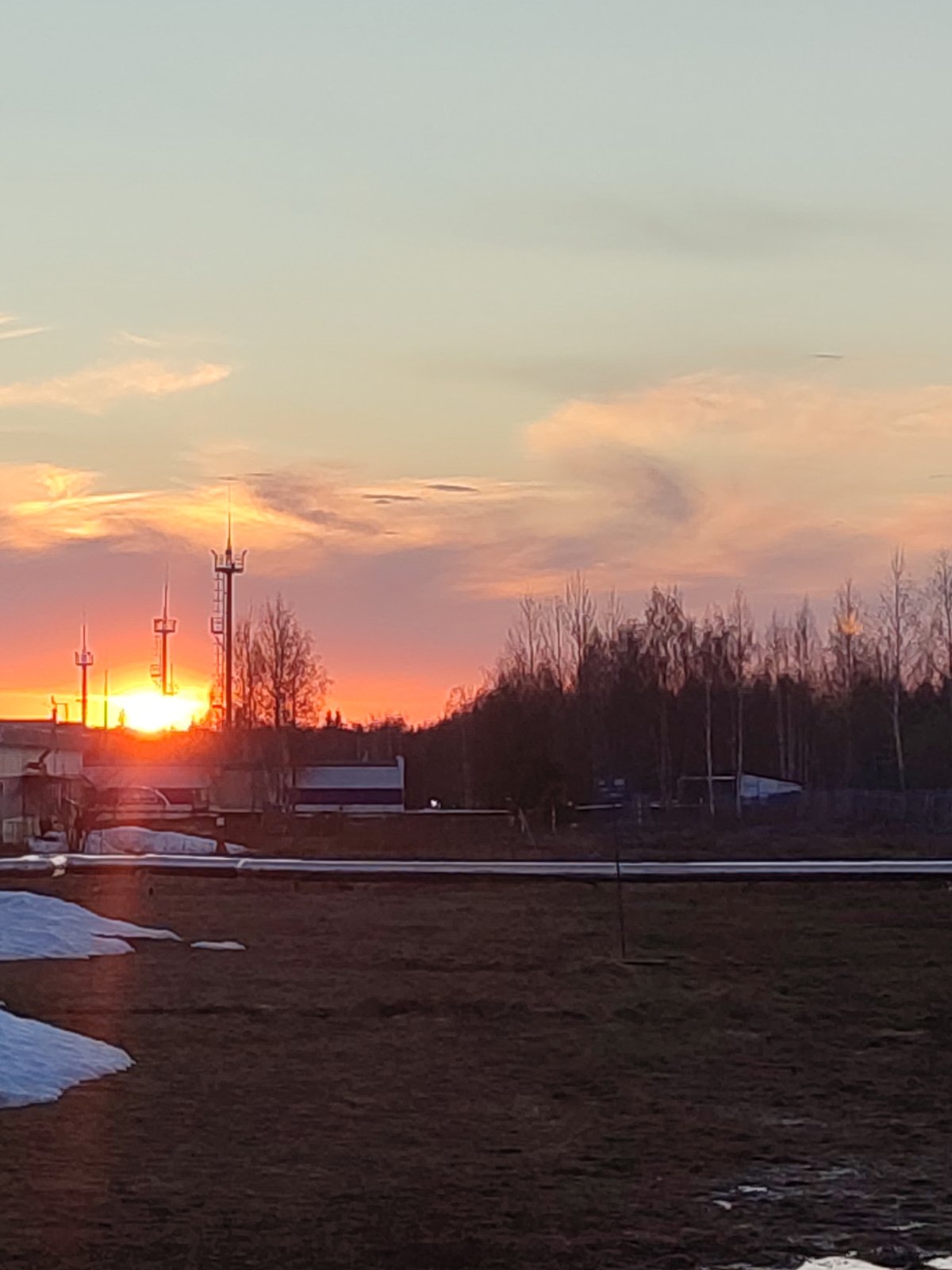 Sunset captured over urban landscape with communication towers