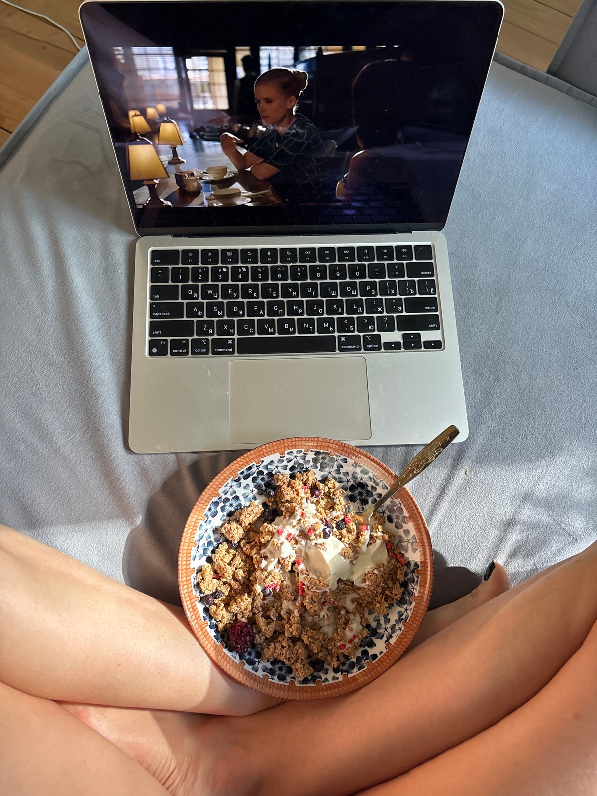 Woman enjoys breakfast in bed with laptop in Chaikovsky