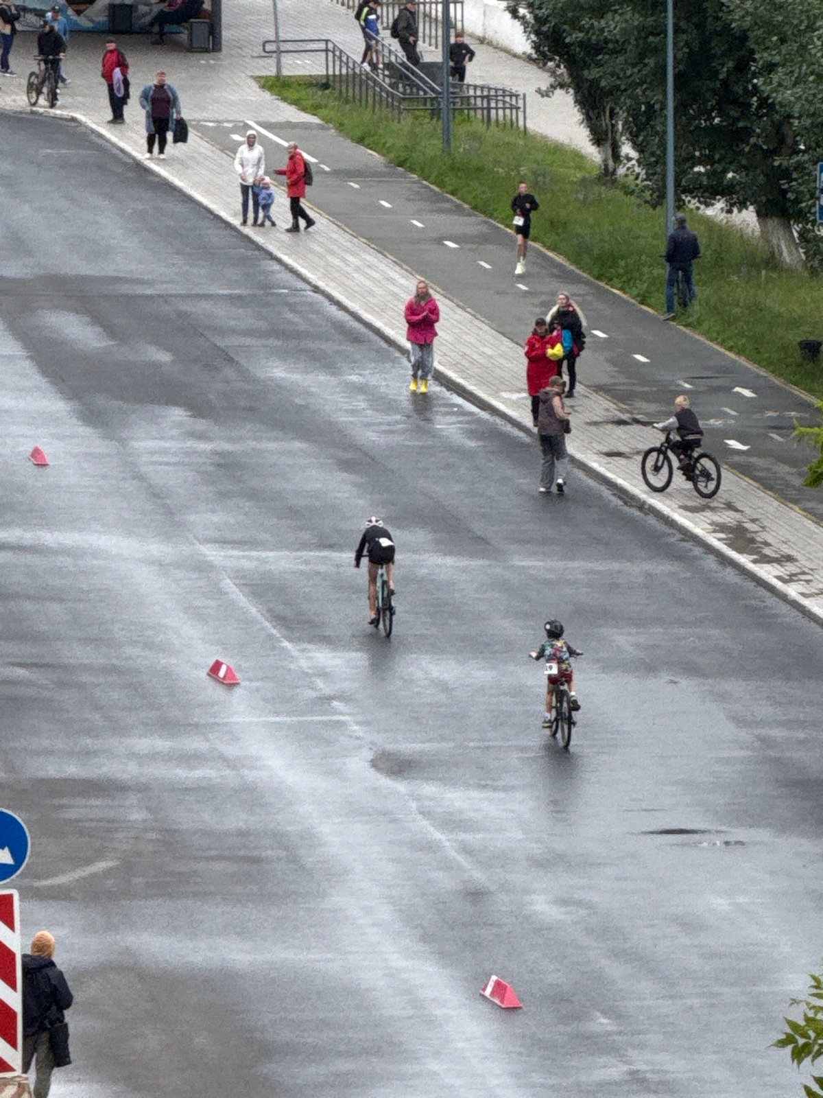 Cyclists roll through wet Votkinsk streets during a morning event