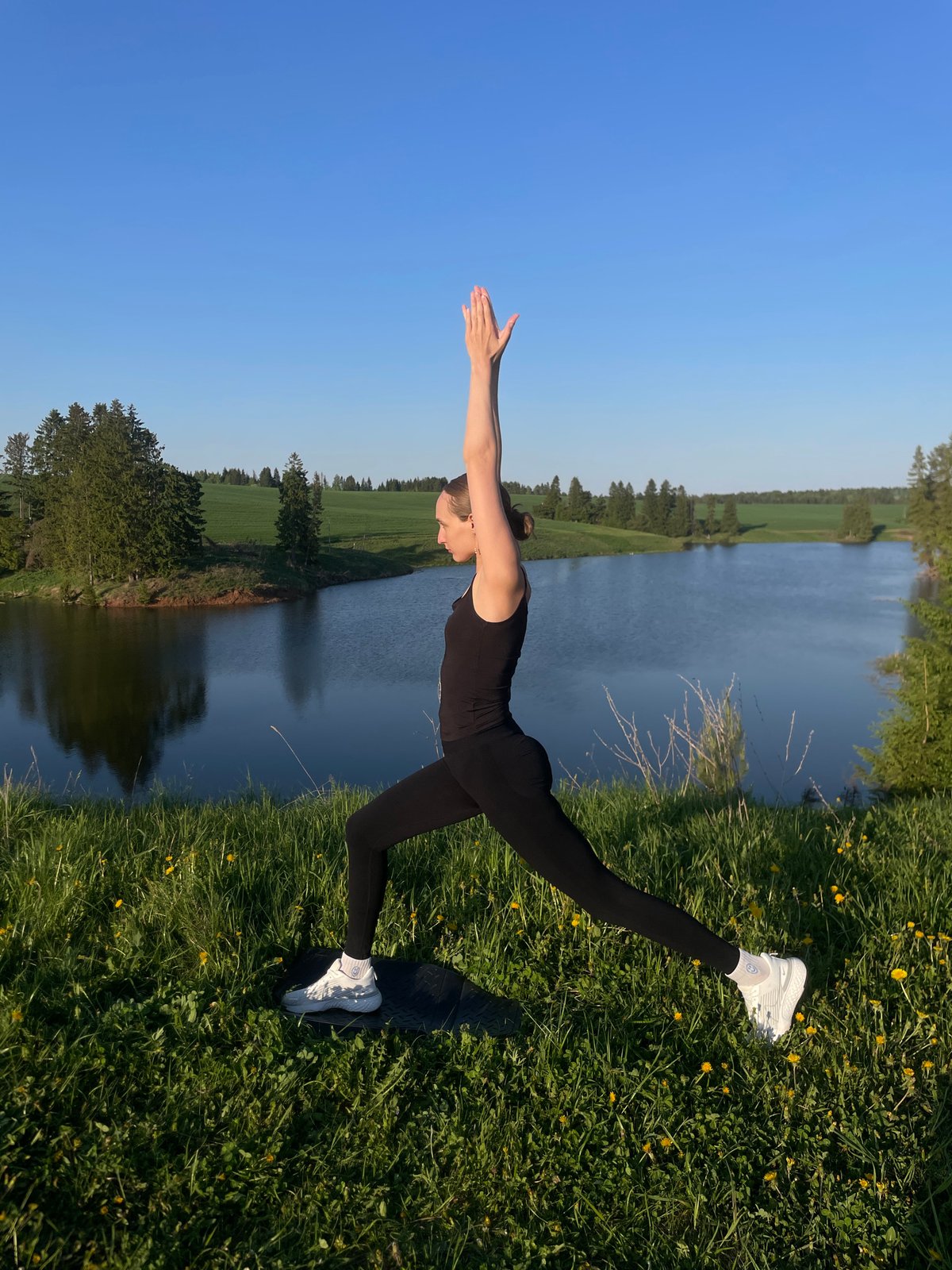 Yoga practitioners exercise by waterside in Podshivalovo, Russia