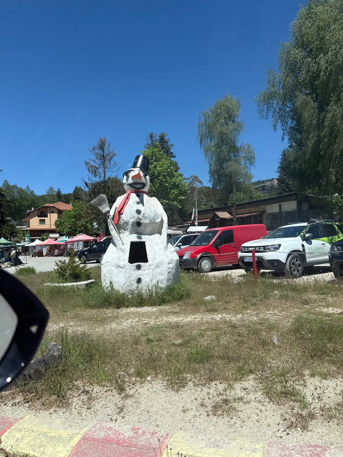 Car journey documented through small town with snowman statue