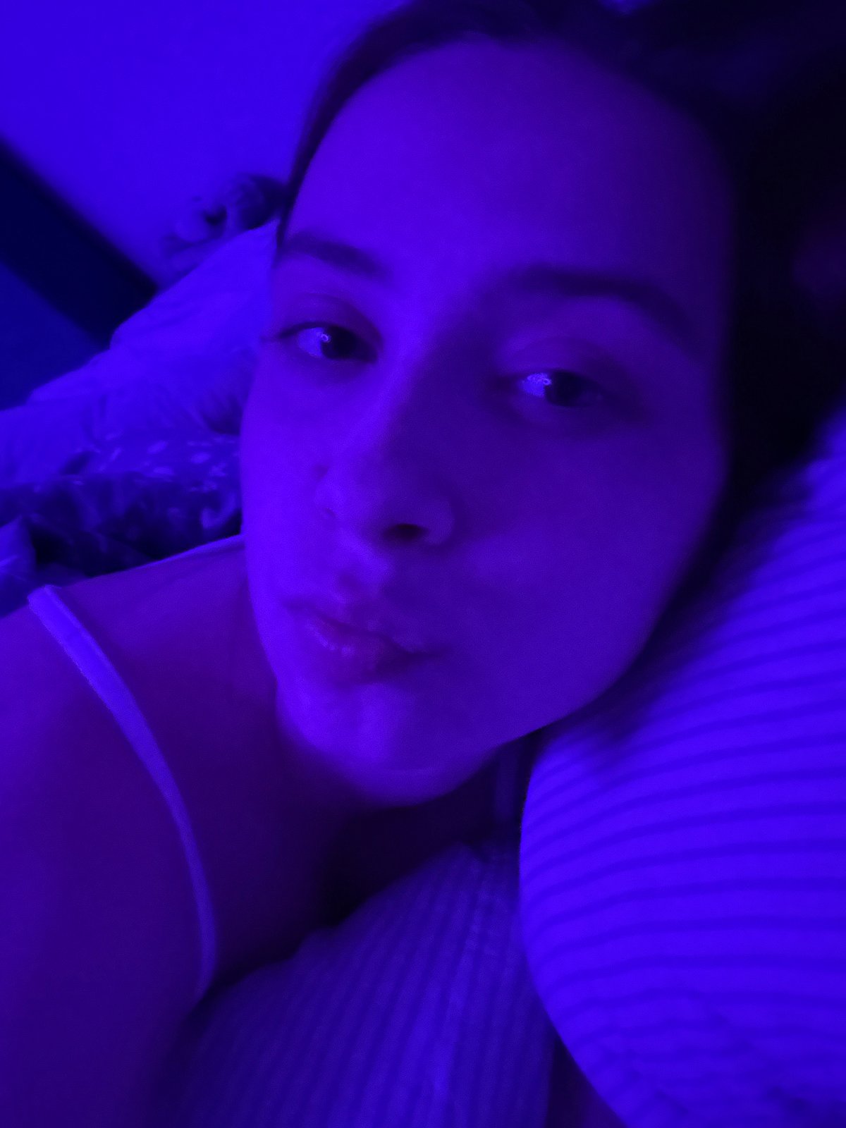 Young woman captures personal moments during bedroom photo session