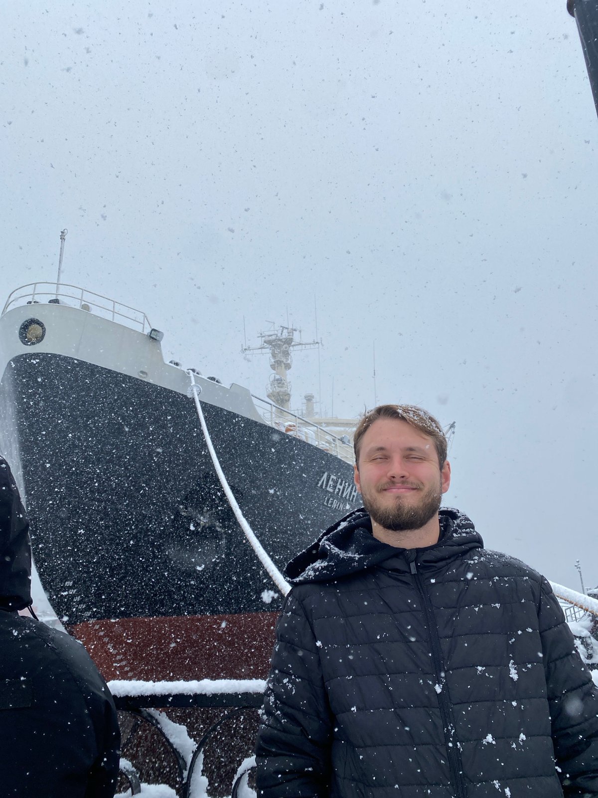 Tourist photographs Lenin Icebreaker museum in snowy Murmansk